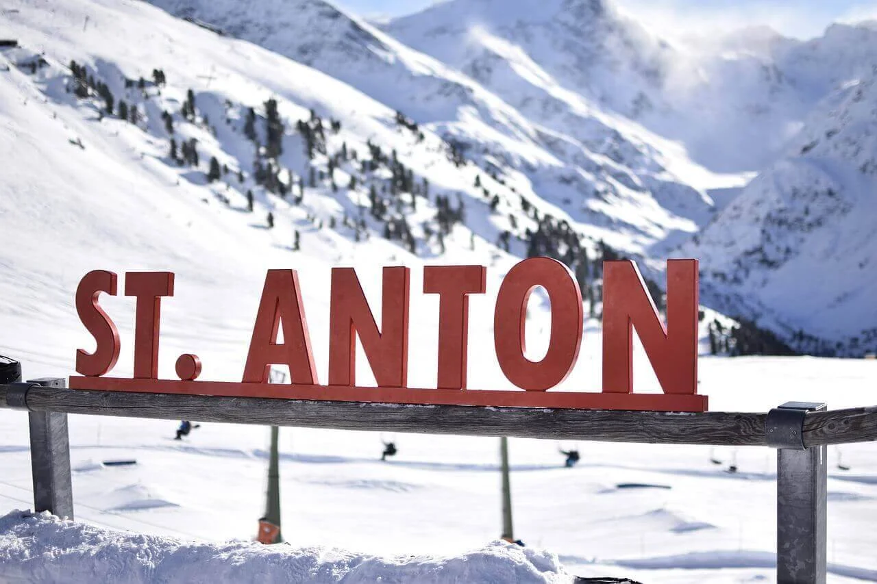 Sign at St. Anton Ski Resort with majestic mountain slopes in the background.