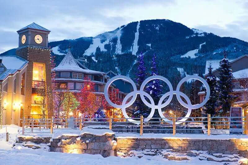 Whistler Village with the iconic Olympic sign, framed by scenic mountain slopes in the background